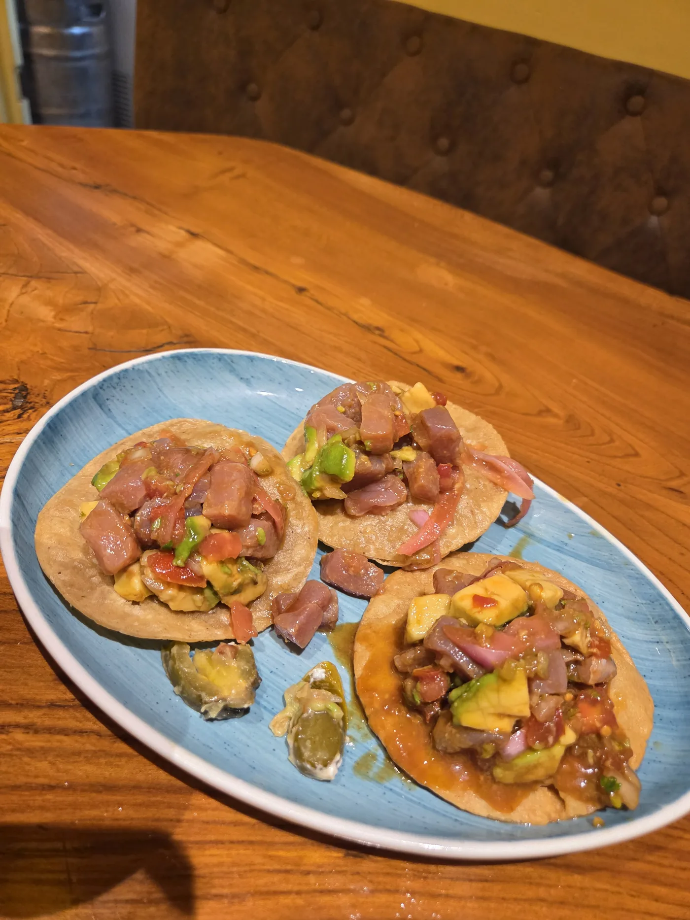Three tacos on a blue plate at Che Taco Valencia